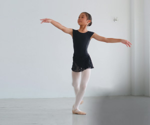 A young Asian female ballet dancer in a practice room