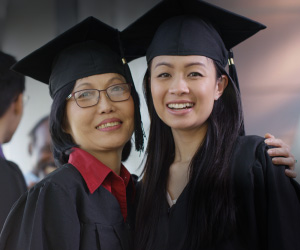An Asian mother and her daughter participate in a graduation ceremony