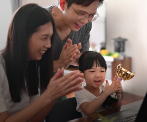 An Asian couple celebrate their daughter winning an award